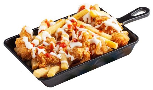 Loaded fries in a skillet with cheese and chicken